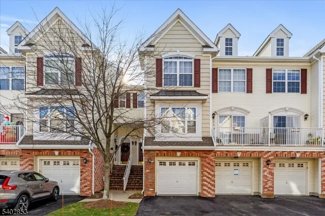 a view of a white house with a large tree