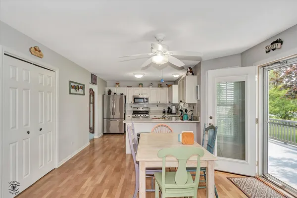a kitchen with kitchen island a appliances dining table and a large window