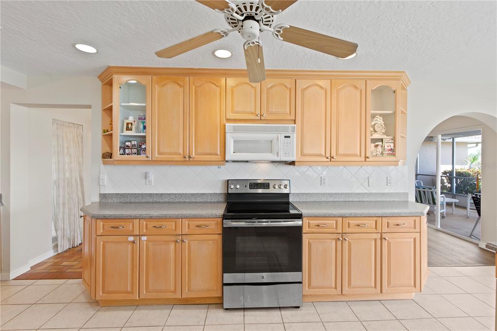 4964 South Shore Drive New Port Richey, FL 34652 - Photo 12 of 69 a kitchen with granite countertop a stove a sink and a refrigerator