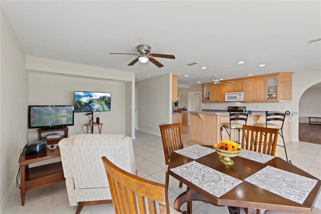 4964 South Shore Drive New Port Richey, FL 34652 - Photo 20 of 69 a living room with dining table a rug and kitchen view