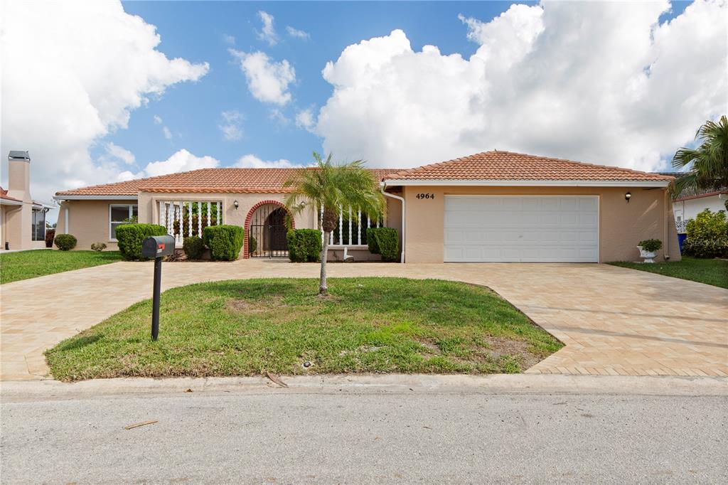 4964 South Shore Drive New Port Richey, FL 34652 - Photo 3 of 69 a front view of a house with a garden