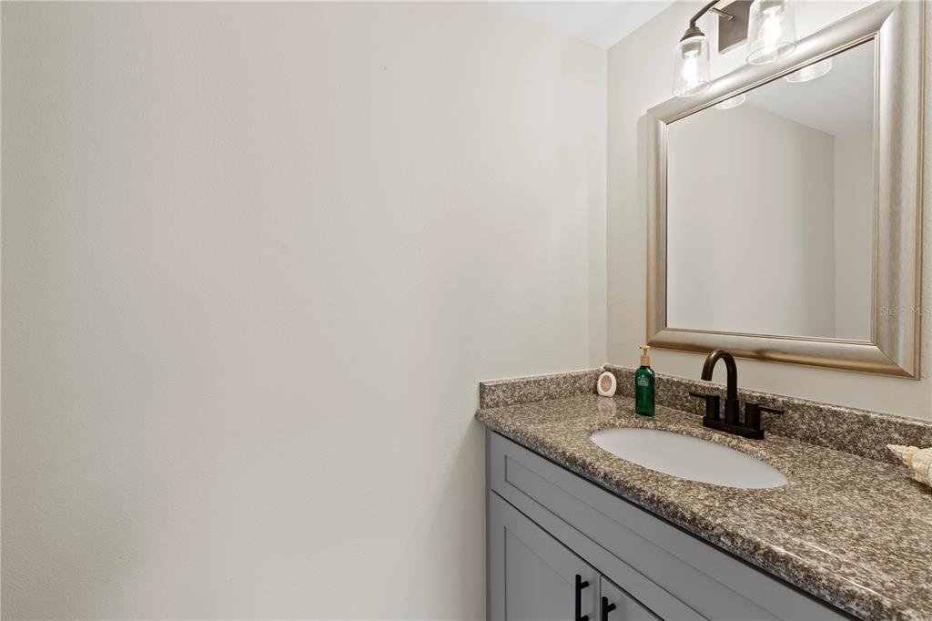 4964 South Shore Drive New Port Richey, FL 34652 - Photo 35 of 69 a bathroom with a granite countertop sink and a mirror