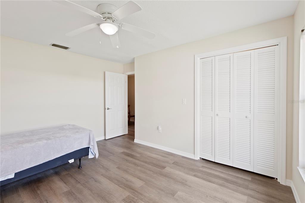 4964 South Shore Drive New Port Richey, FL 34652 - Photo 37 of 69 an empty room with wooden floor and fan