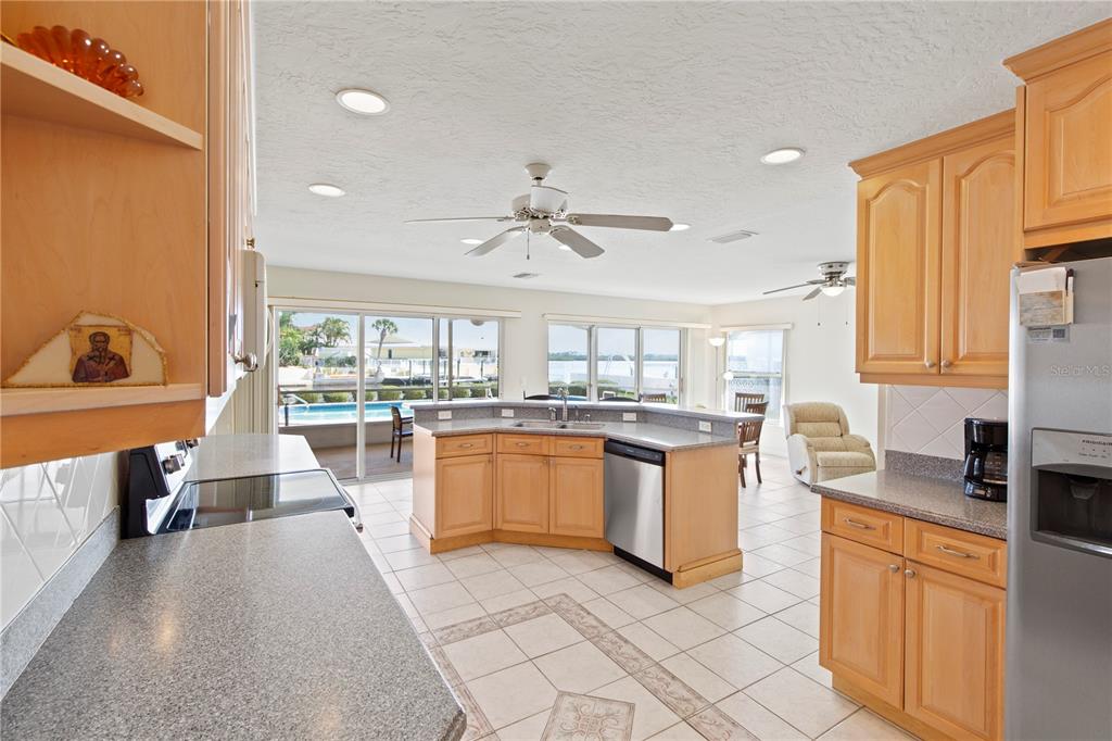 4964 South Shore Drive New Port Richey, FL 34652 - Photo 9 of 69 a large kitchen with kitchen island a large counter top space a sink a window and stainless steel appliances