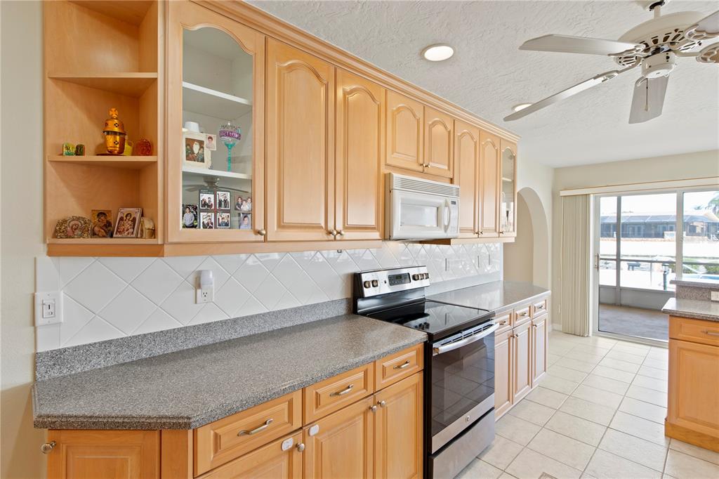 4964 South Shore Drive New Port Richey, FL 34652 - Photo 10 of 69 a kitchen with stainless steel appliances granite countertop a stove and a sink