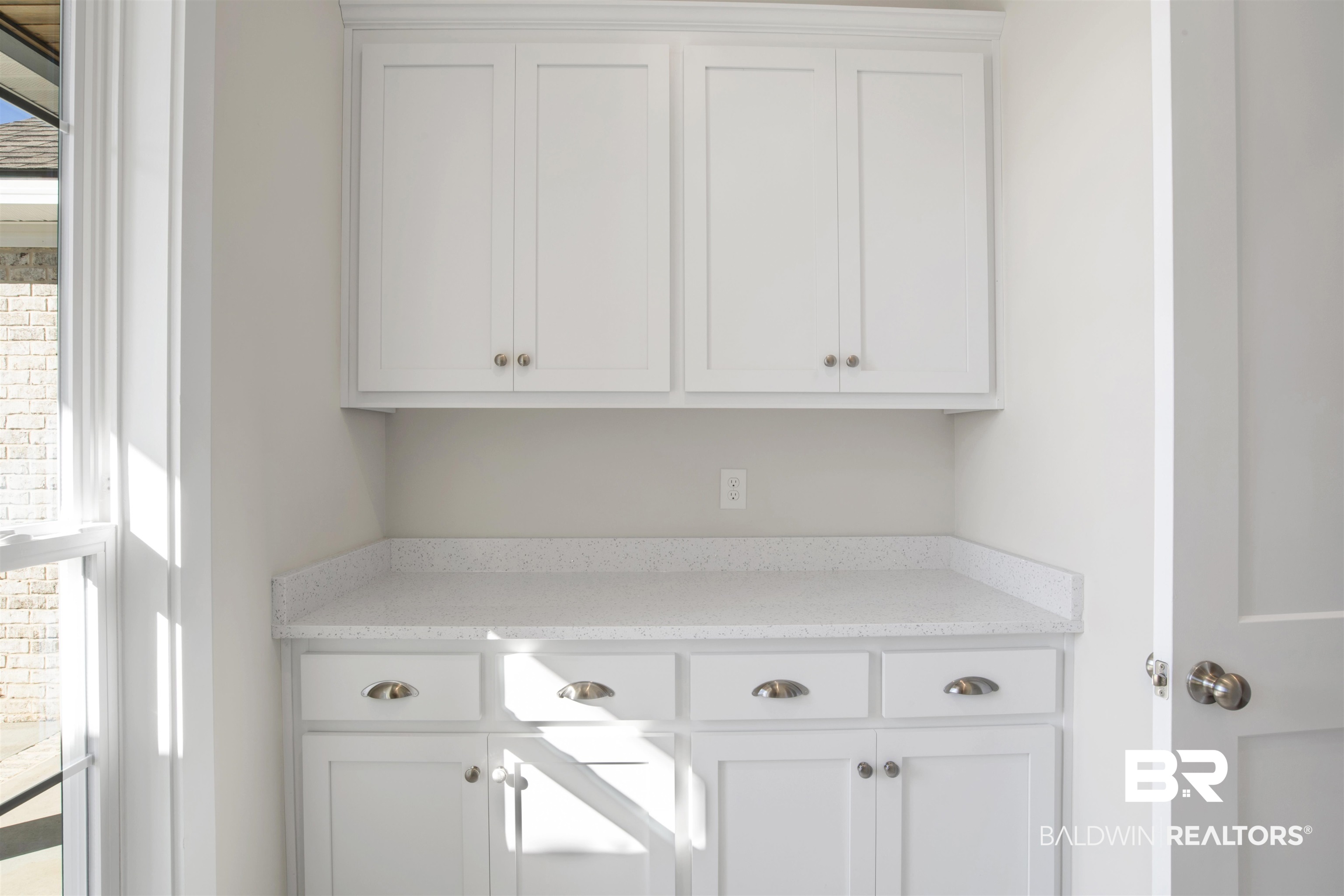 9687 Widgeon Court Daphne, AL 36526 - Photo 28 of 40 Storage featuring white cabinets, a healthy amount of sunlight, and light stone countertops