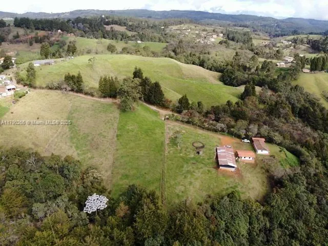 an aerial view of residential houses with outdoor space and trees