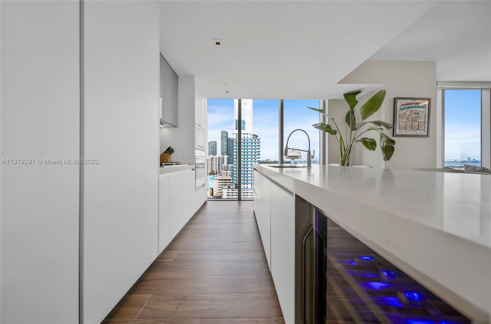 Edgewater Miami, FL 33137 - Photo 9 of 23 a kitchen with stainless steel appliances granite countertop lots of counter top space and wooden floor