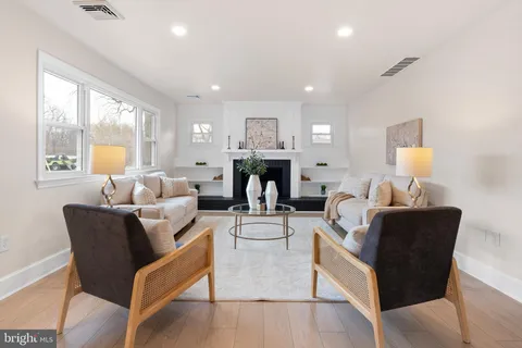 a living room with furniture a large window and a fireplace