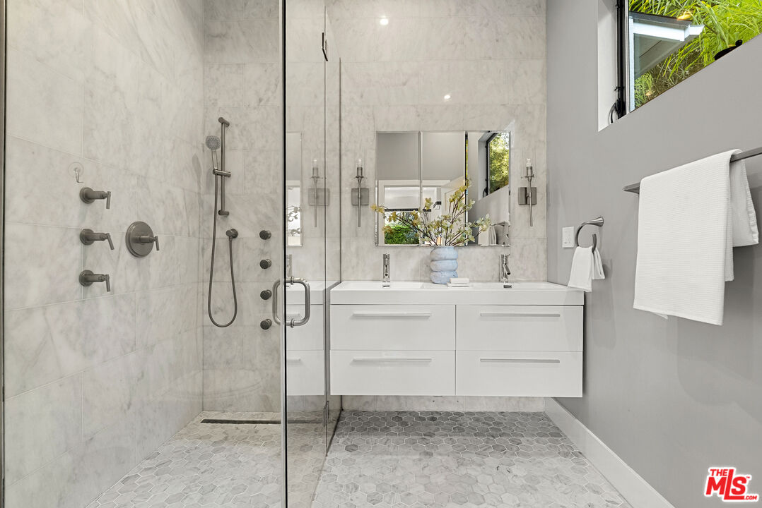 9782 Oak Pass Road Beverly Hills, CA 90210 - Photo 16 of 27 a bathroom with a shower sink and mirror