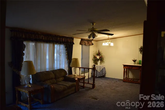 a living room with furniture a ceiling fan and a window