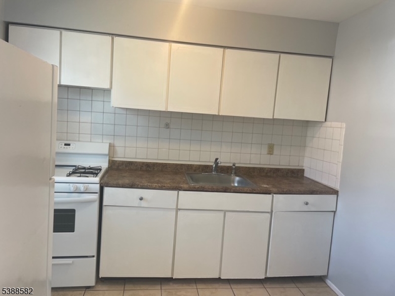 2467 Highway 10 Morris Plains, NJ 07950 - Photo 6 of 11 a kitchen with granite countertop white cabinets and white appliances