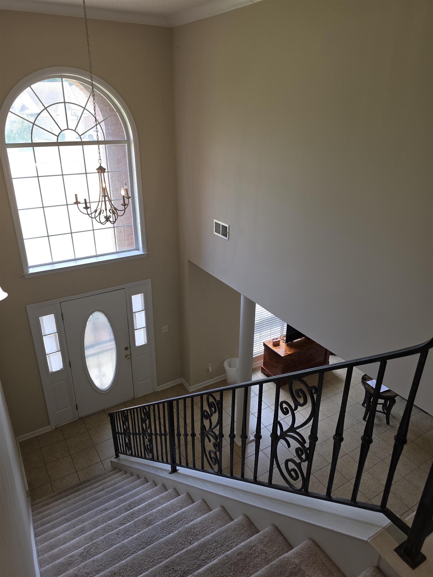 7253 Rourke Circle Memphis, TN 38125 - Photo 26 of 31 Grand entryway featuring a two-story ceiling, arched picture window, decorative chandelier, and an elegant wrought iron staircase railing