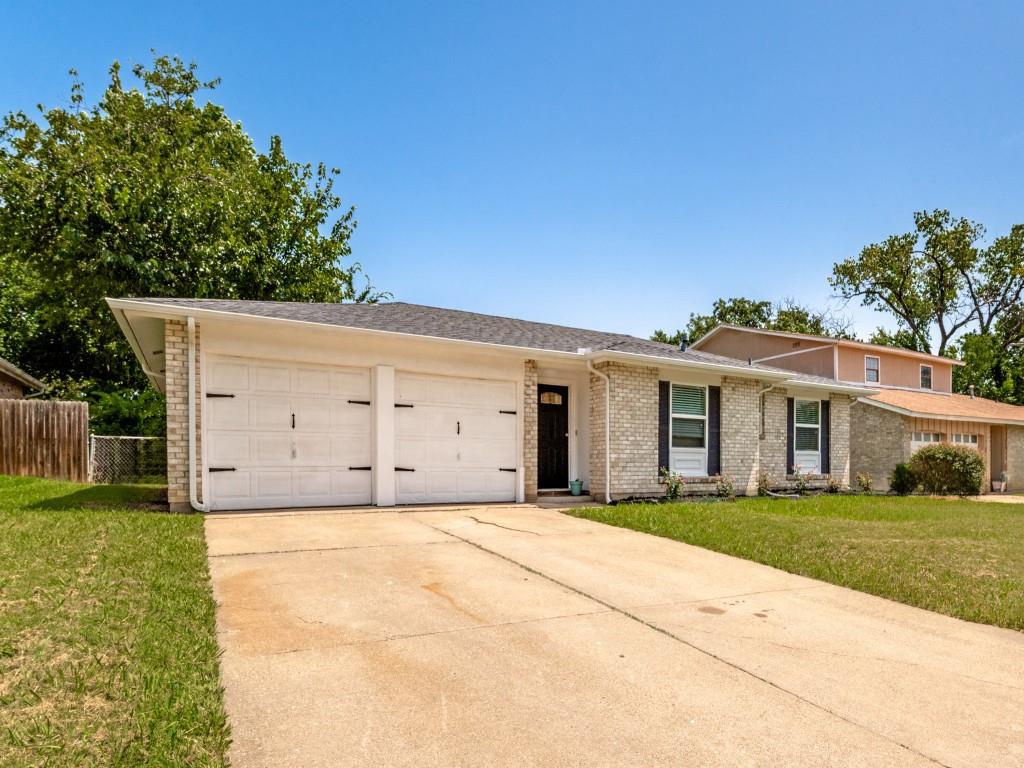 1405 Rambler Road Arlington, TX 76014 - Photo 2 of 26 Brick exterior with a prominent two-car garage featuring carriage-style doors