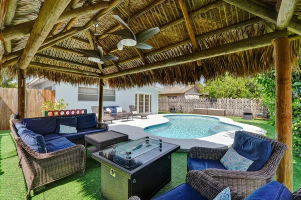 a view of a house with backyard swimming pool and sitting area
