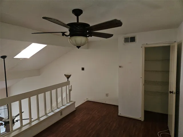 a view of a room with wooden floor and a ceiling fan