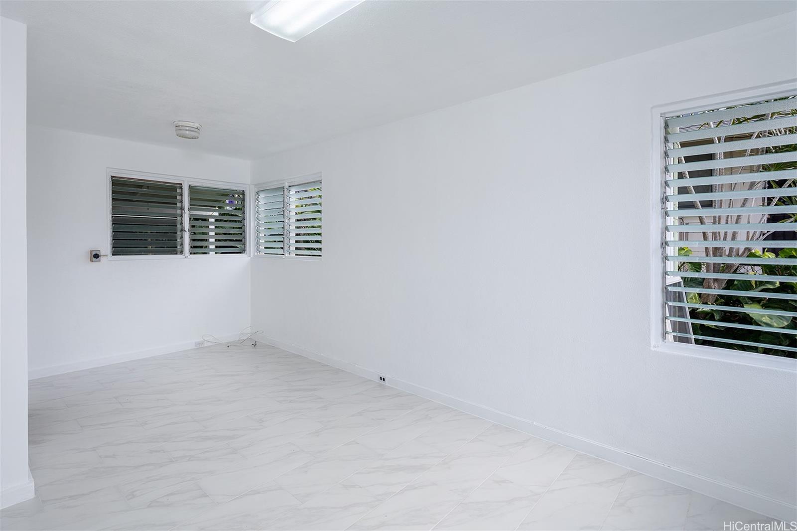 1115 Hassinger Street, Unit C Honolulu, HI 96822 - Photo 4 of 11 an empty room with windows