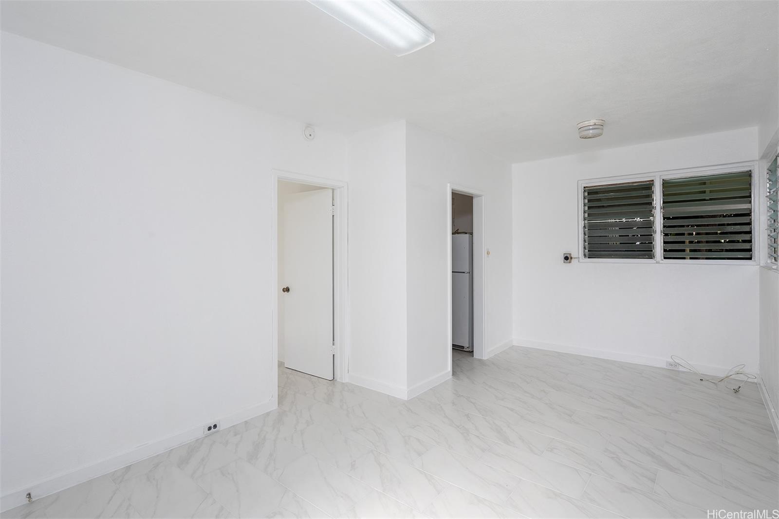 1115 Hassinger Street, Unit C Honolulu, HI 96822 - Photo 5 of 11 an empty room with windows