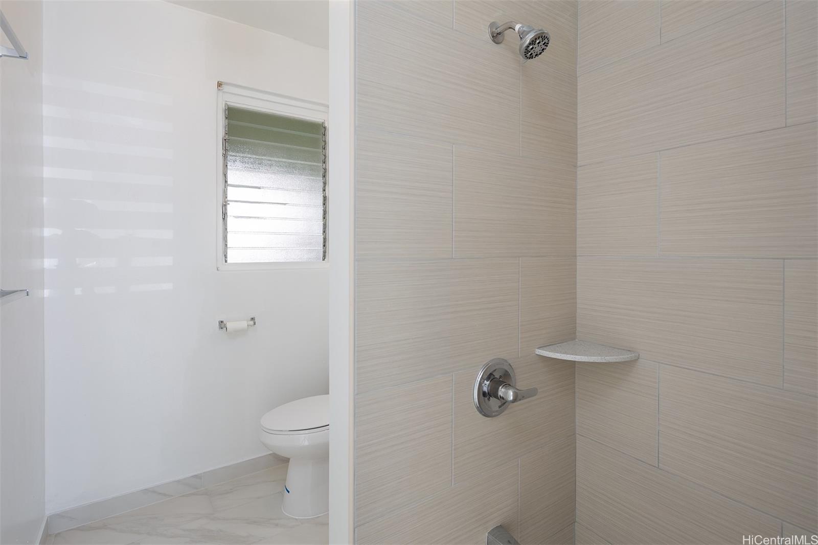 1115 Hassinger Street, Unit C Honolulu, HI 96822 - Photo 9 of 11 a bathroom with a granite countertop toilet and a shower