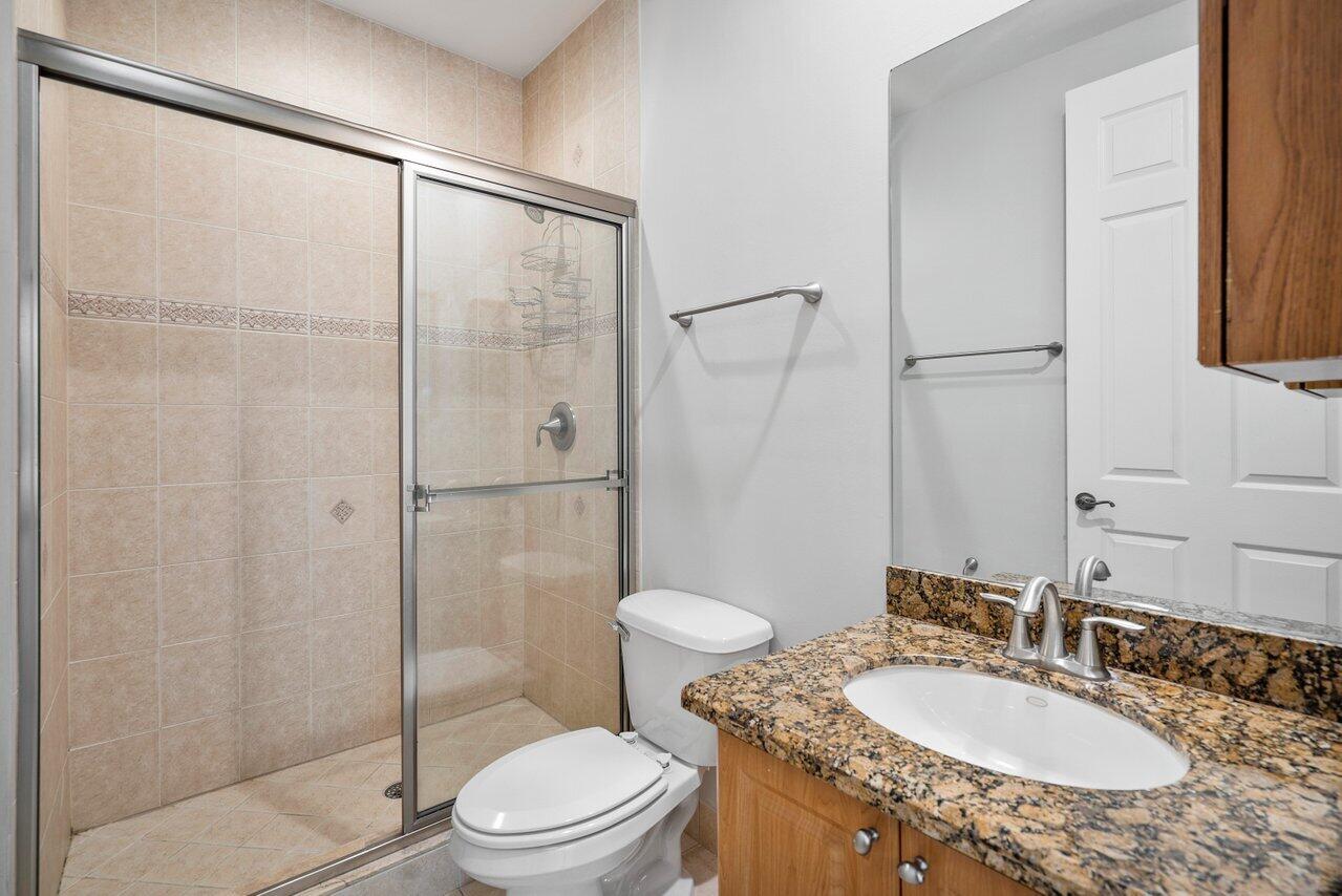 3025 Waterside Circle Boynton Beach, FL 33435 - Photo 24 of 36 a bathroom with a granite countertop sink toilet and shower