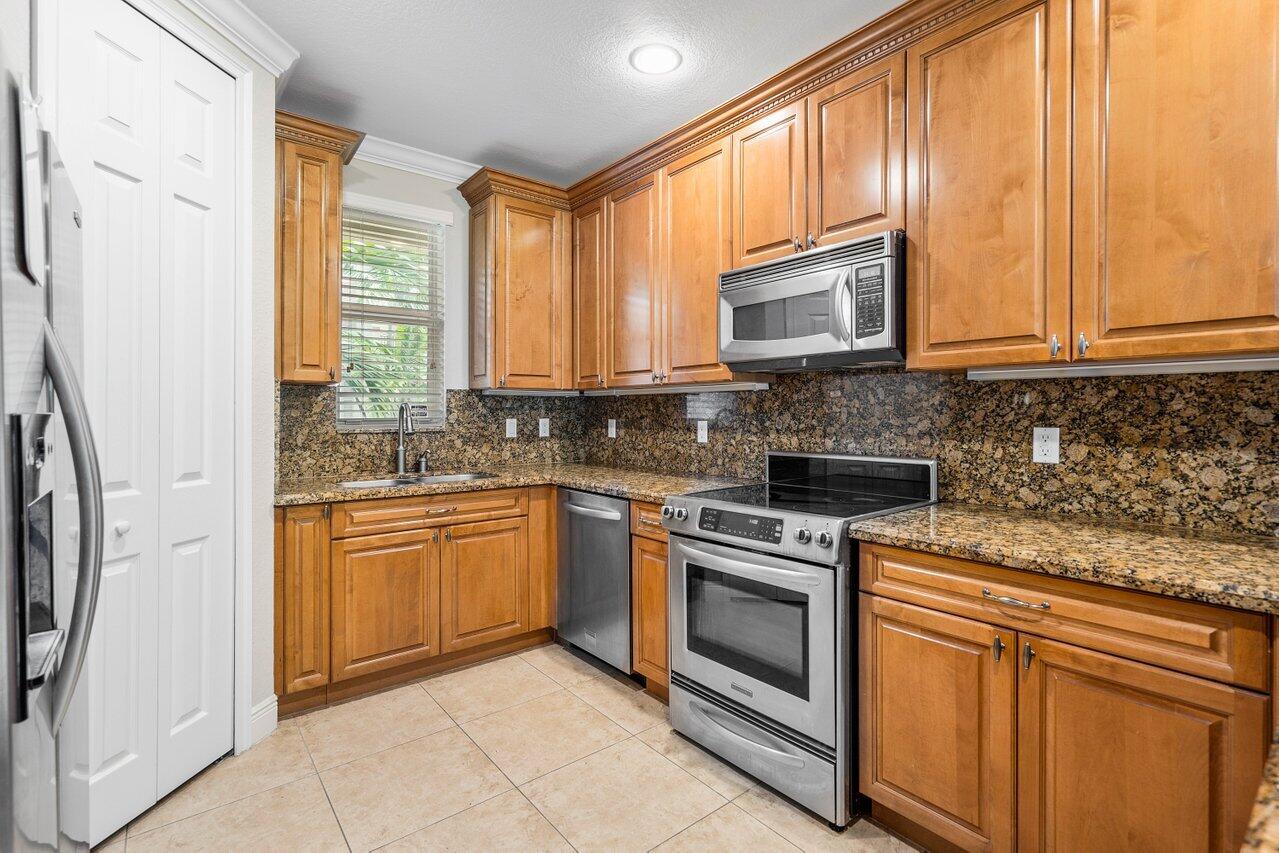 3025 Waterside Circle Boynton Beach, FL 33435 - Photo 7 of 36 a kitchen with stainless steel appliances granite countertop a stove a sink and a microwave