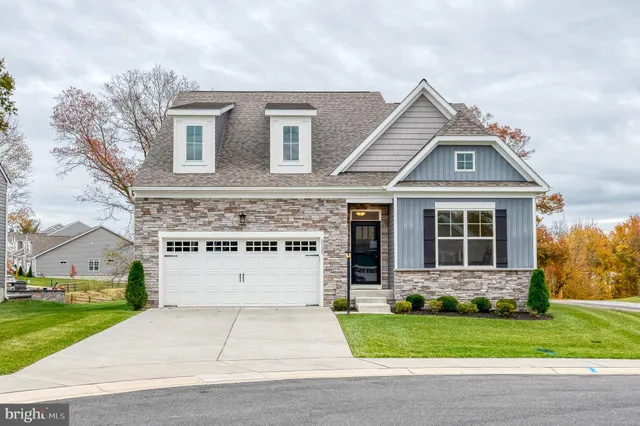 a view of a white house with a big yard and large trees