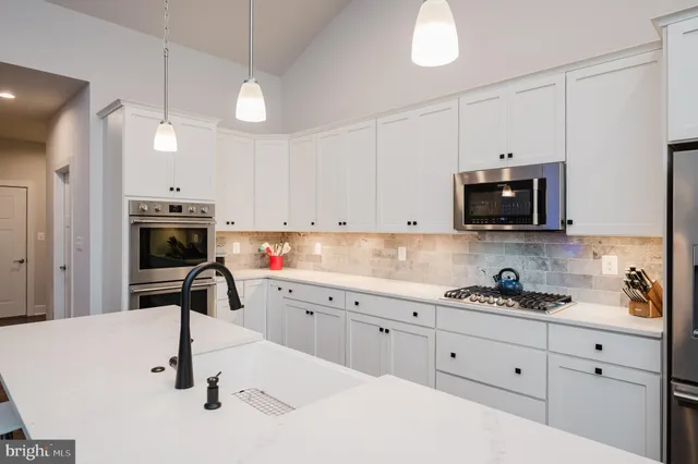 a kitchen with a sink appliances and cabinets