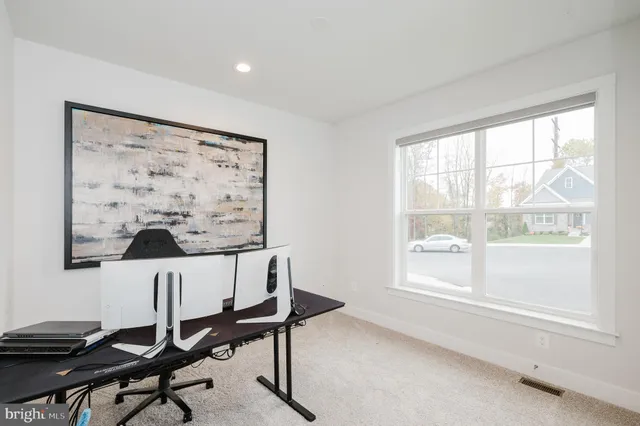 a view of a workspace with furniture and a window