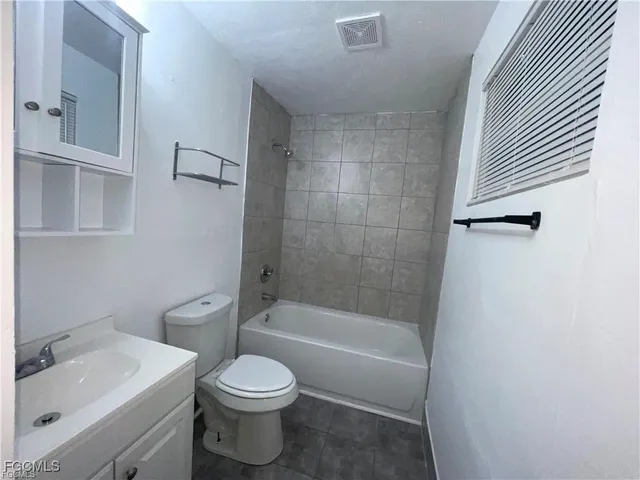 a white toilet sitting next to a bath tub