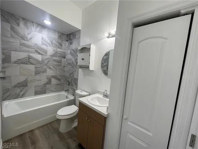 a bathroom with a bathtub shower sink vanity and toilet