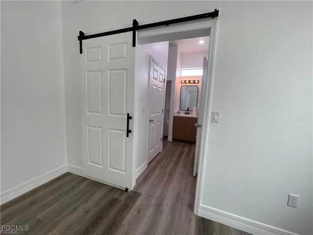 a view of a hallway with wooden floor and closet