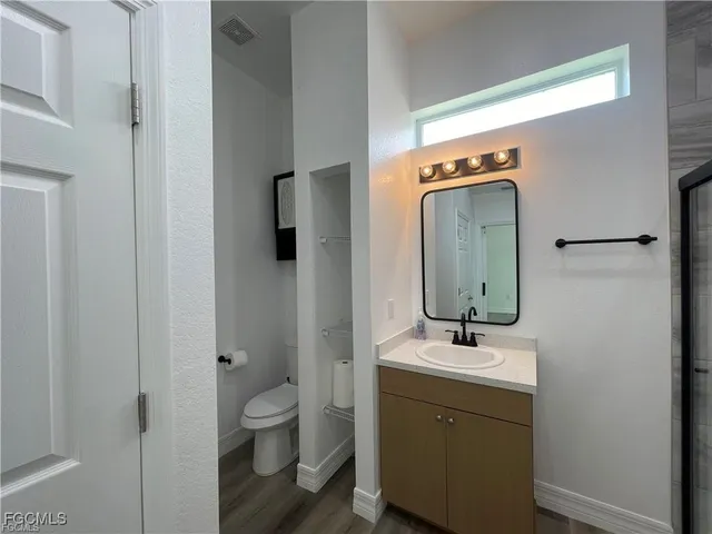 a bathroom with a toilet a sink and mirror