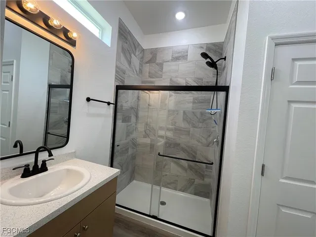 a bathroom with a sink a mirror and shower