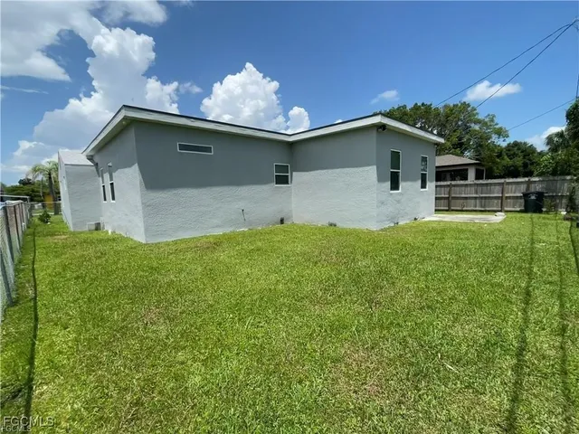 a front view of house with yard and trees in the background