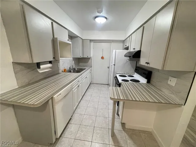a kitchen with stainless steel appliances a sink stove and cabinets