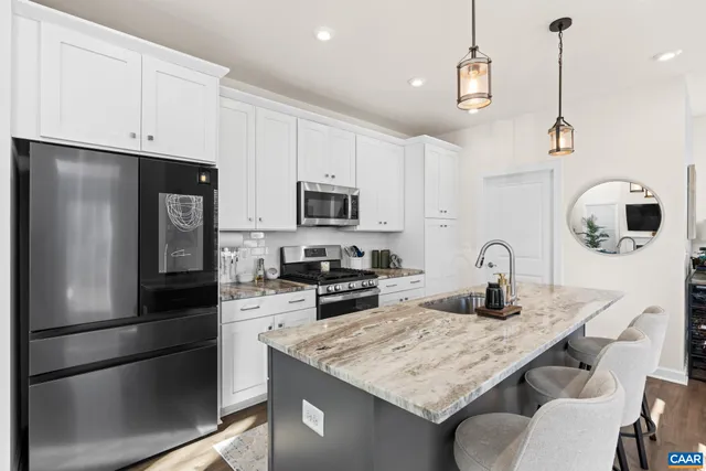 a kitchen with stainless steel appliances granite countertop a sink a stove and a refrigerator