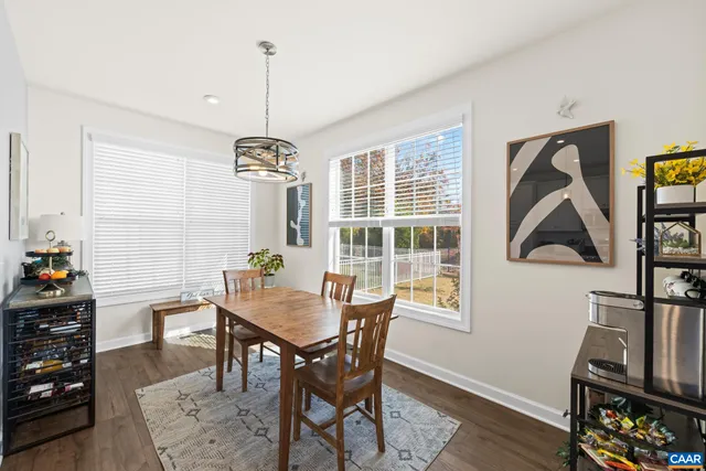 a kitchen with stainless steel appliances granite countertop a stove top oven a sink dishwasher a refrigerator and white cabinets with wooden floor