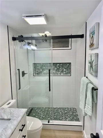 a bathroom with a granite countertop sink a toilet and shower