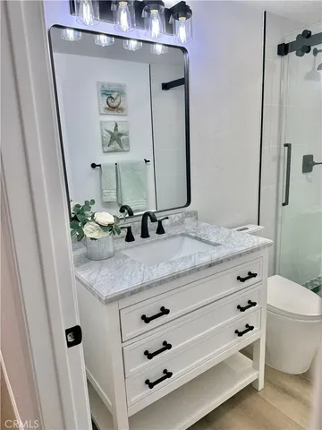 a bathroom with a granite countertop sink a toilet and a mirror
