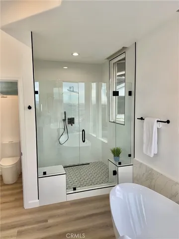 a bathroom with a tub shower and toilet