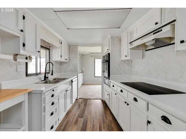 a kitchen with granite countertop a sink and cabinets