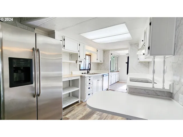 a kitchen with stainless steel appliances kitchen island a refrigerator sink and cabinets