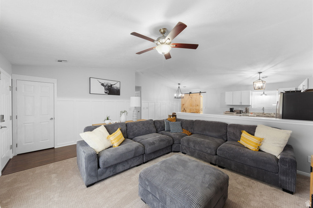 664 East Springhill Drive Washington, UT 84780 - Photo 7 of 21 Carpeted living area featuring a ceiling fan with integrated lighting, wainscoting details, and wood-finish flooring at the entry