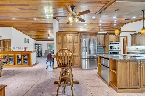 a bedroom with a bed a chandelier and dresser