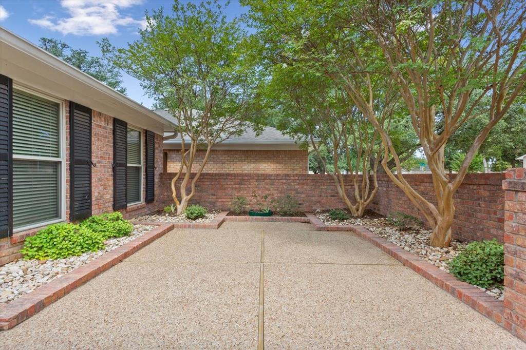 4108 Old Mill Road Waco, TX 76710 - Photo 3 of 39 Brick residence with modern architectural details and a generous front courtyard featuring mature shade trees, decorative river rock landscaping, and bordered planting beds