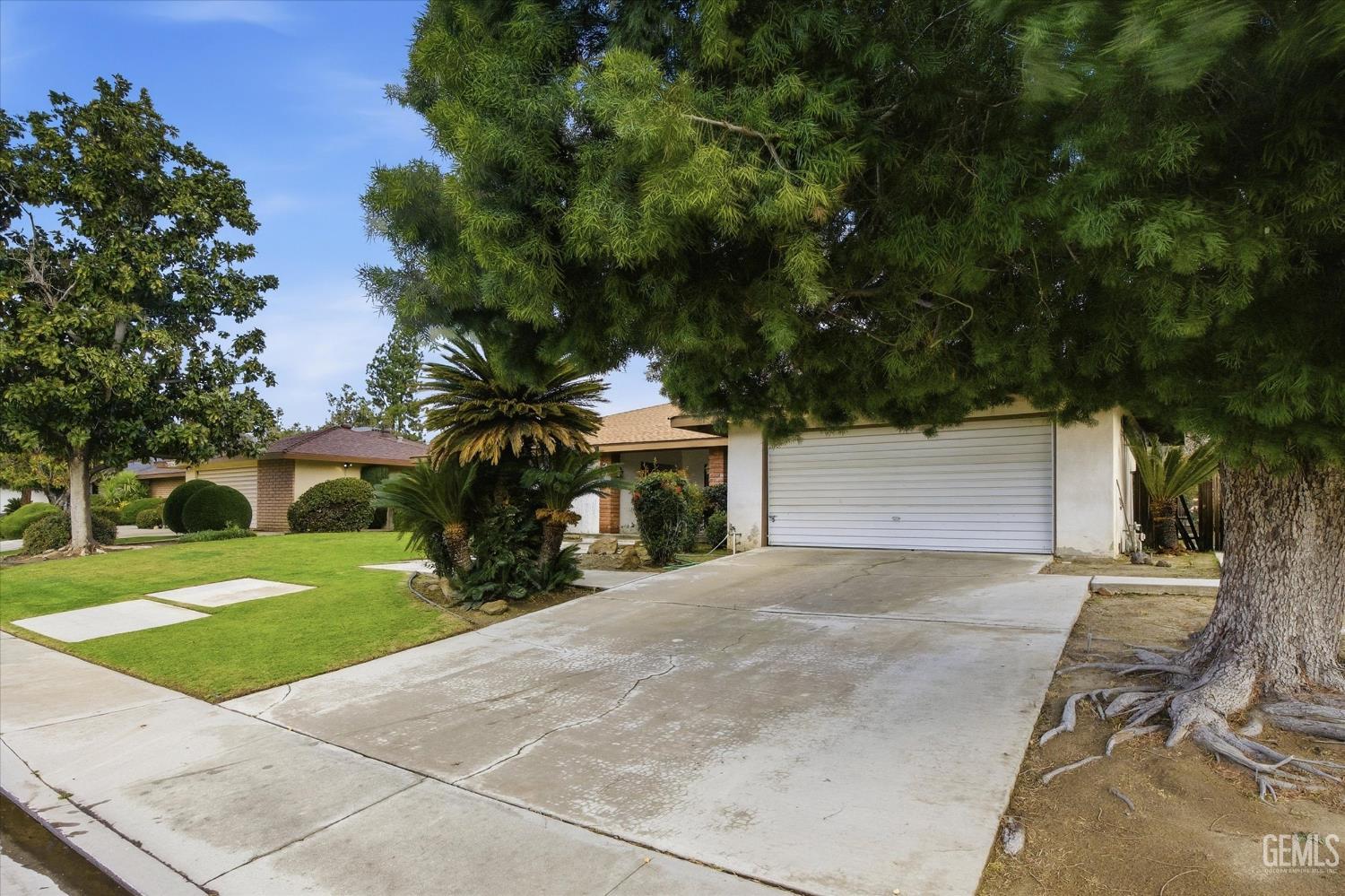 Undisclosed Address Bakersfield, CA 93309 - Photo 14 of 41 a view of a house with a yard and a garage