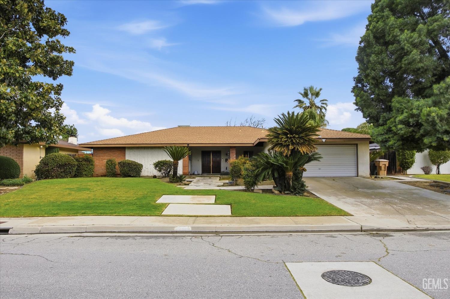Undisclosed Address Bakersfield, CA 93309 - Photo 15 of 41 a front view of a house with a yard and garage