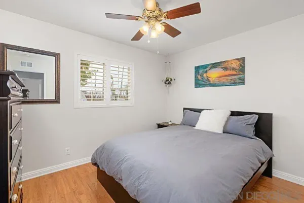 a bedroom with a bed and a painting on the wall