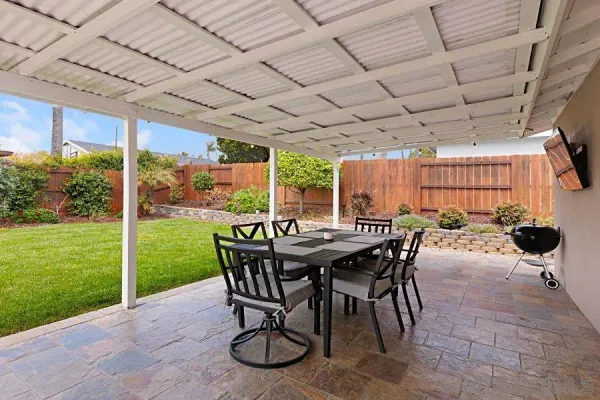 a view of a patio with a table chairs and a backyard