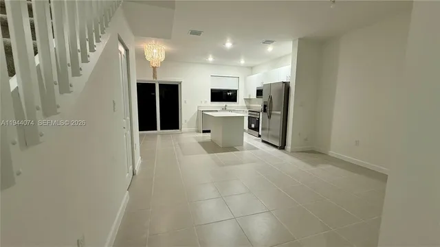 a view of a kitchen with a sink and an empty room